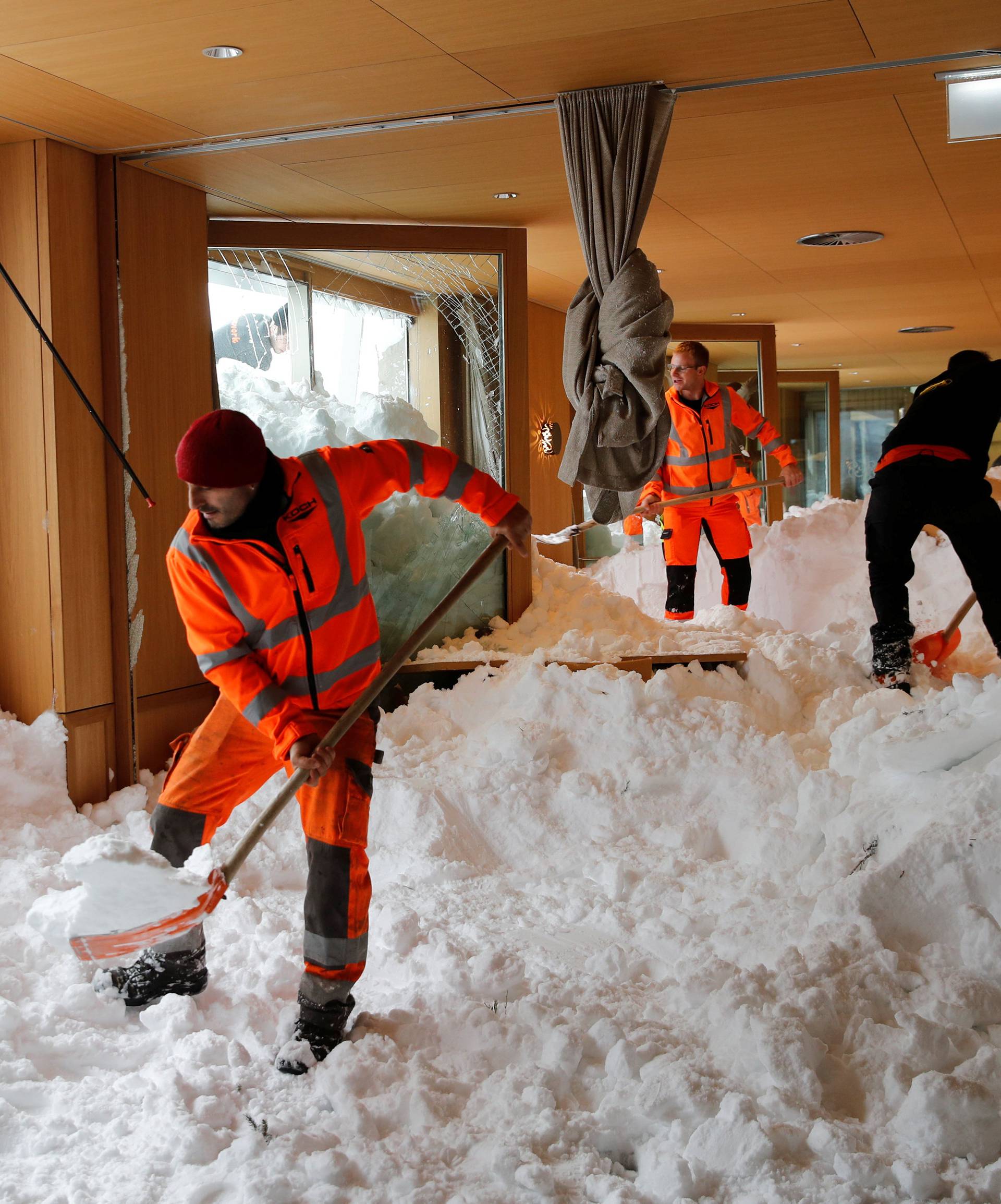 Workers shovel snow out of a restaurant after an avalanche at Santis-Schwaegalp
