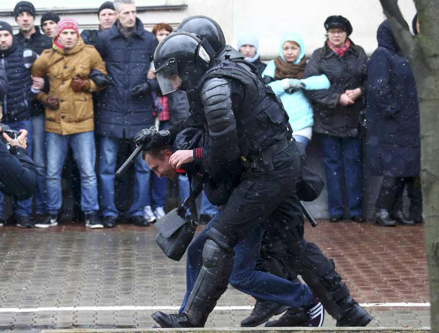 Law enforcement officers detain a man during a gathering which marks the anniversary of the proclamation of the Belarussian People's Republic in Minsk
