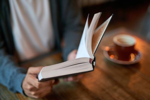 Hands,,Person,And,Book,With,Coffee,At,Cafe,In,Table