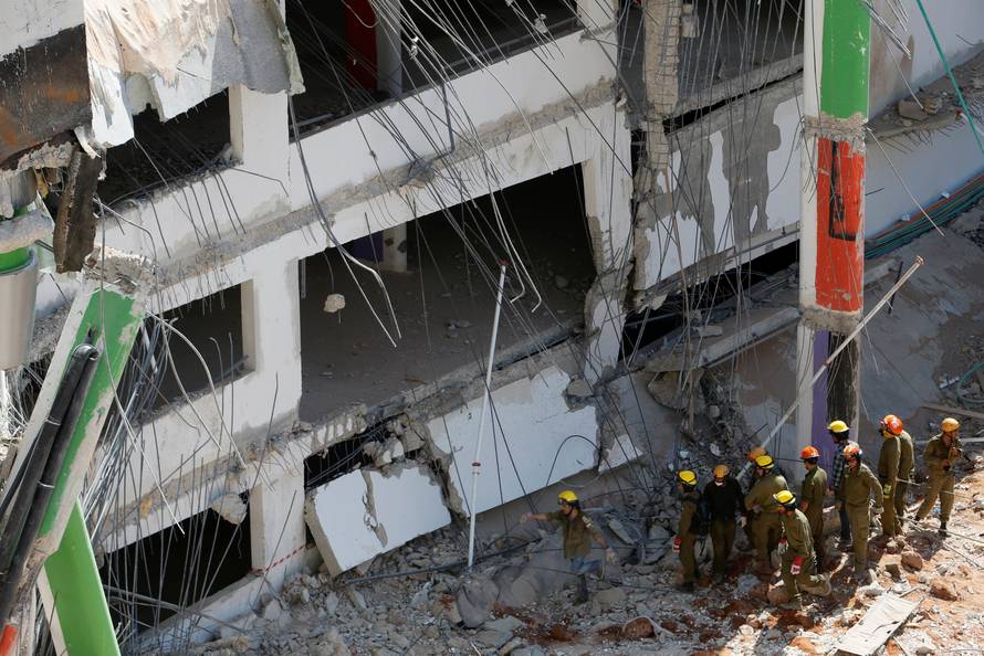 Israeli rescue services search through the rubble after a building site collapsed in Tel Aviv