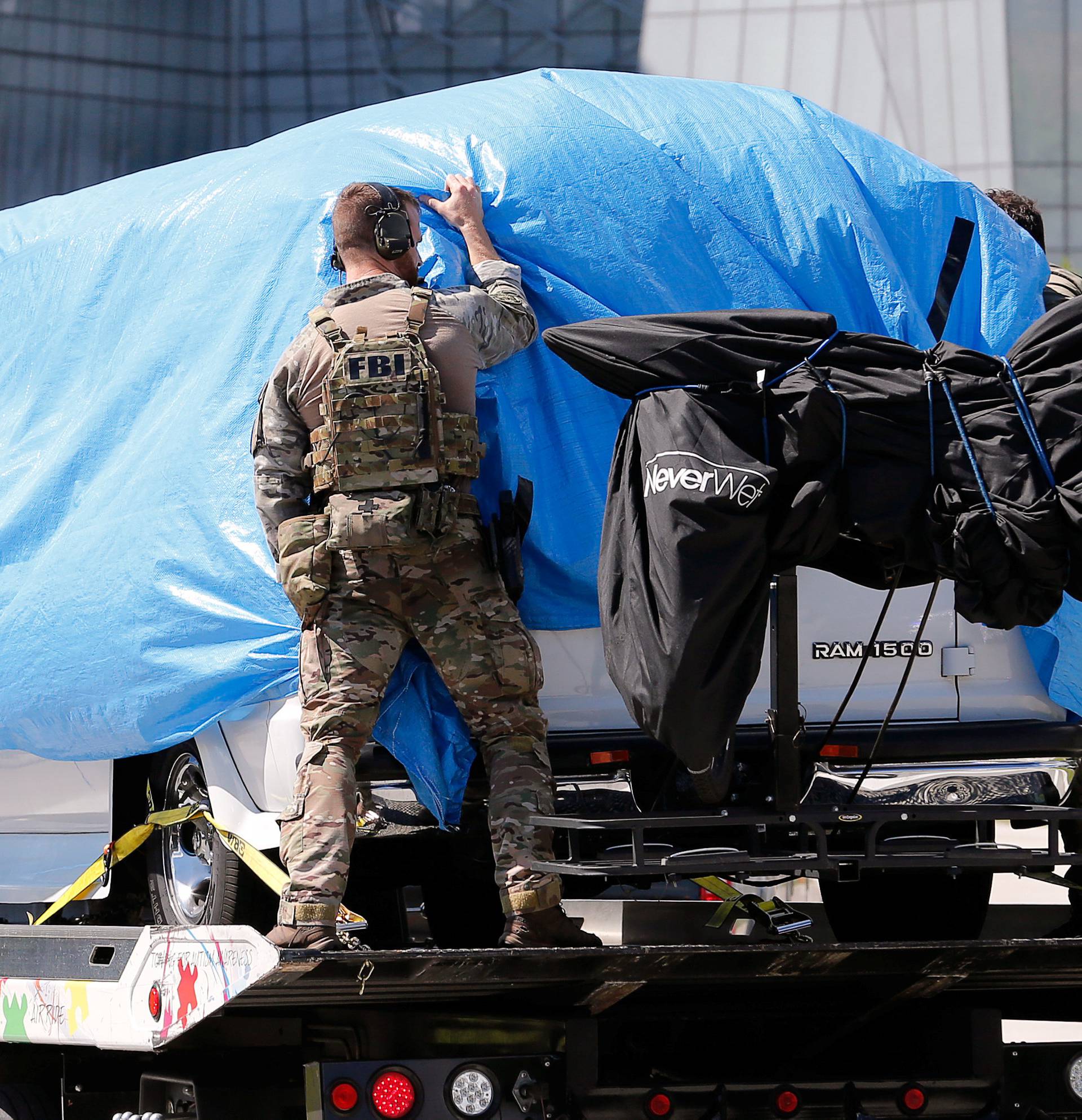 A white van seized during an investigation into a series of parcel bombs is towed into FBI headquarters in Miramar