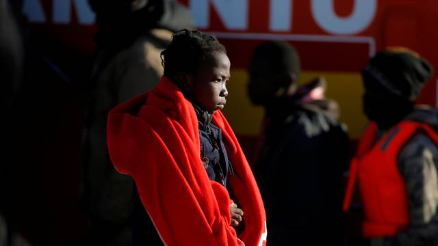 A migrant child walks after disembarking a rescue boat at the port of Malaga