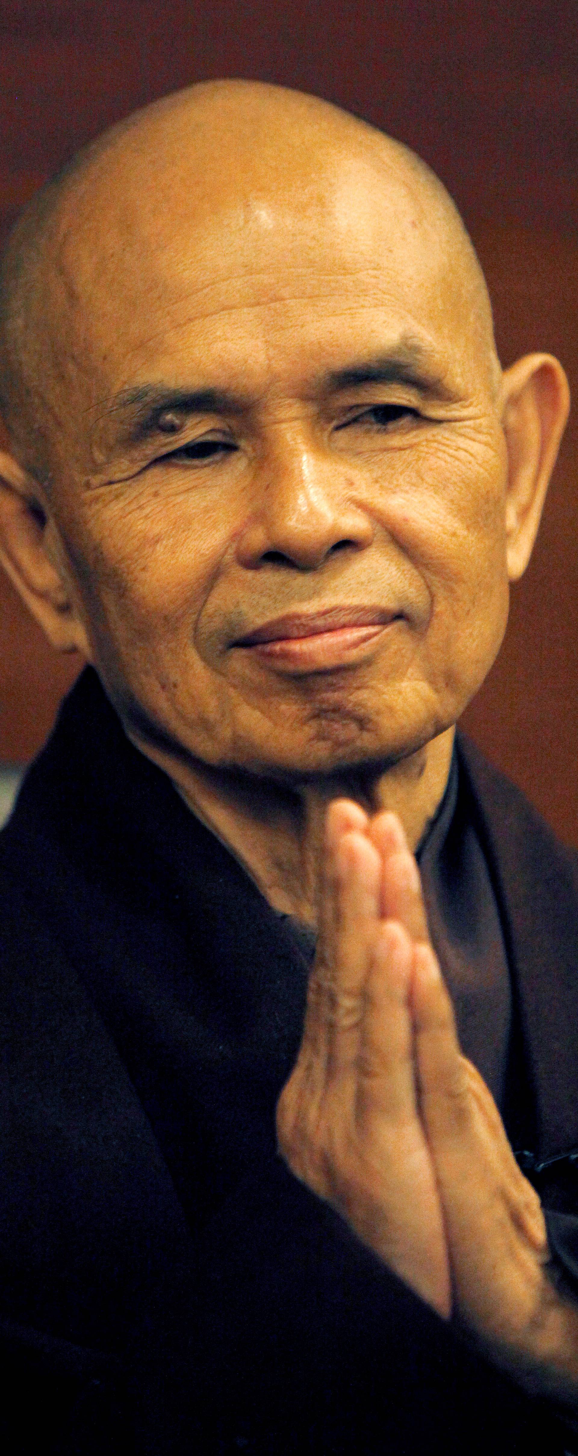 FILE PHOTO: French-based Buddhist zen master Thich Nhat Hanh gestures during his arrival at Suvarnabhumi airport in Bangkok