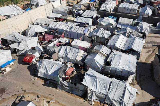Palestinians displaced during the two-year Israeli offensive, shelter at a tent camp in Gaza City