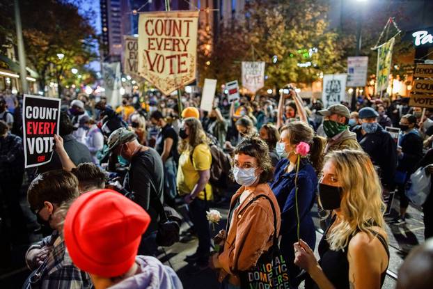 People gather with signs as votes continue to be counted following the 2020 U.S. presidential election, in Philadelphia, Pennsylvania