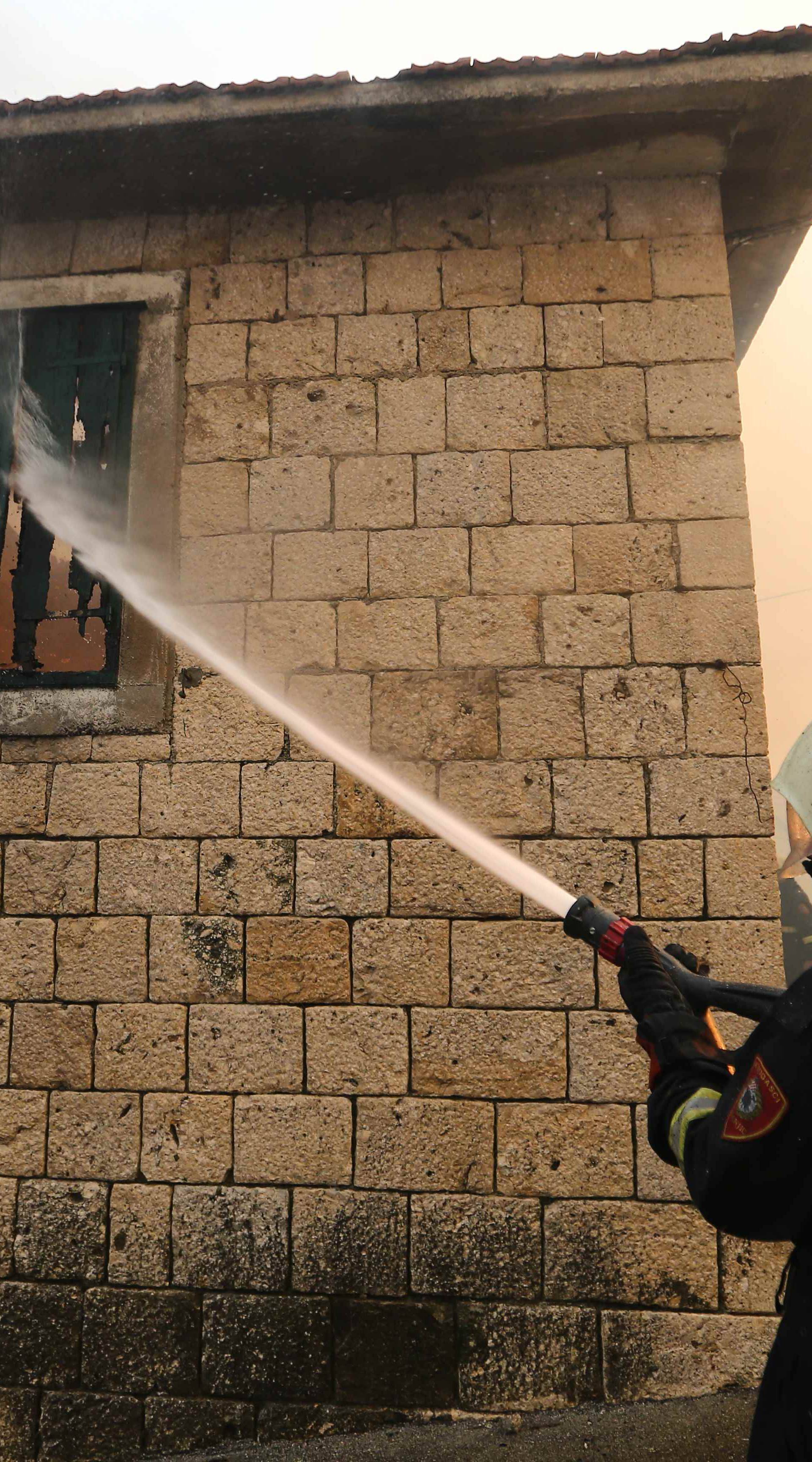 A firefighter tries to extinguish a wildfire in the village of Mravince near Split