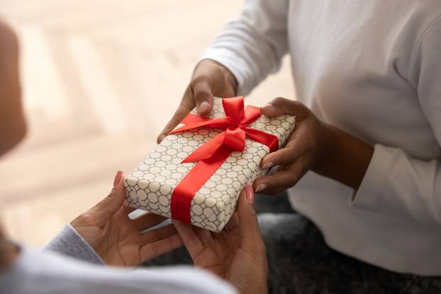Close up of child presenting gift to mom