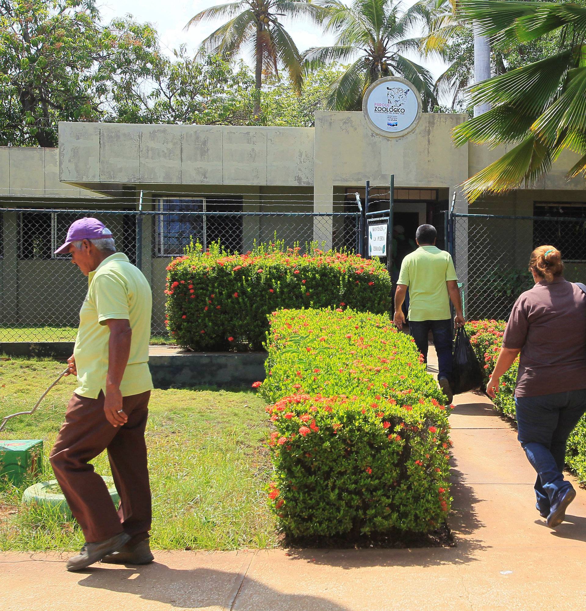 People walk past the entrance of the Zulia's Metropolitan Zoological Park in Maracaibo