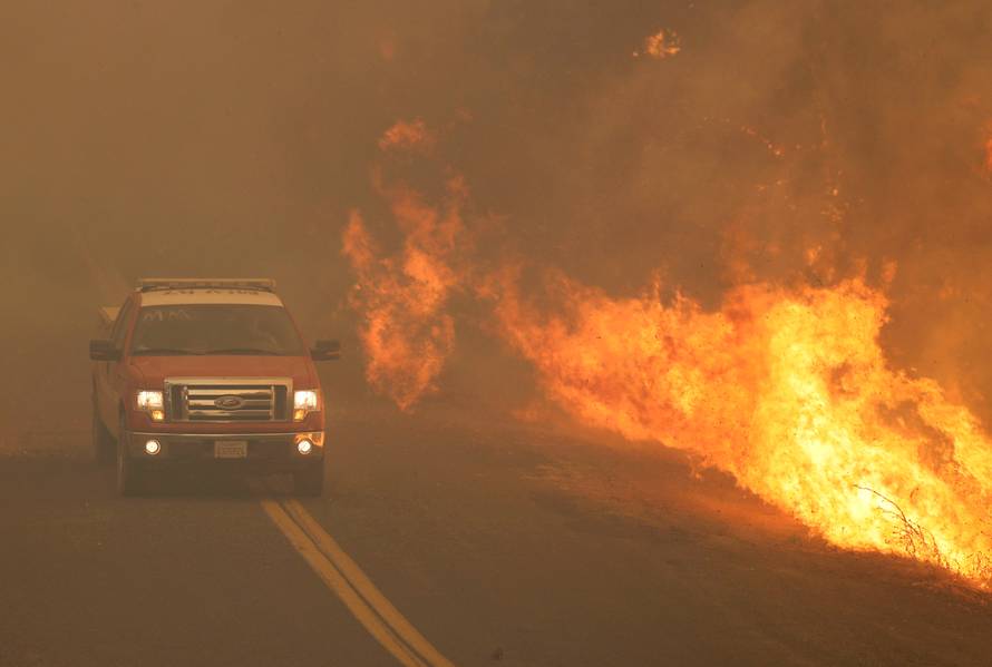 FILE PHOTO: A firetruck rushes past flames that overran a road at the River Fire in Lakeport