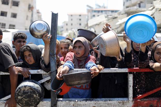 Palestinians receive food from charity kitchen, in Gaza City