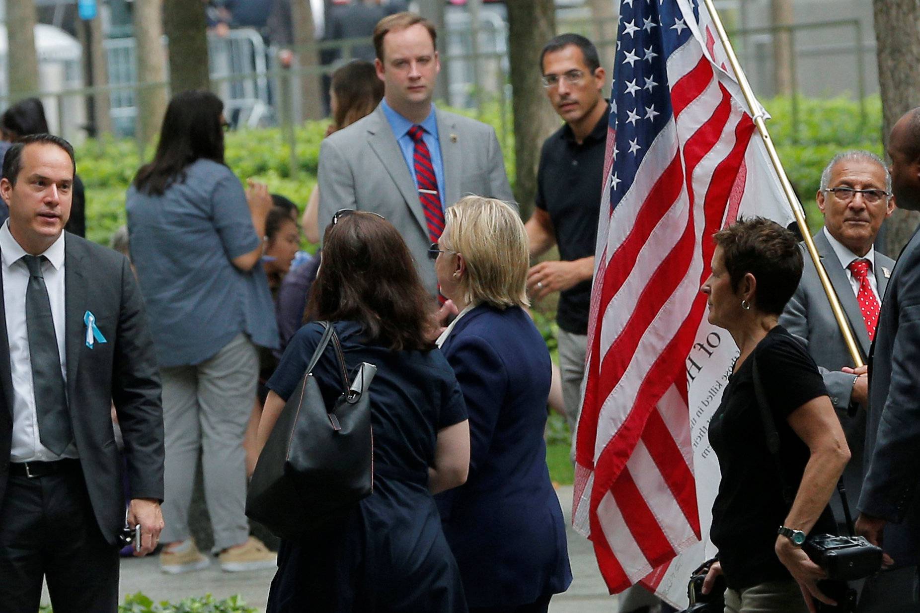 U.S. Democratic presidential candidate Hillary Clinton leaves ceremonies marking the 15th anniversary of the September 11 attacks at the National 9/11 Memorial in New York
