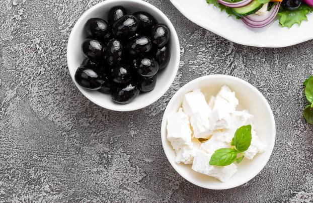 Greek salad. Fresh vegetable salad with tomato, onion, cucumbers, basil, pepper, olives, lettuce and feta cheese. Greek salad on plate