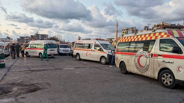 Ambulances are seen during the rescue process of migrants in the port of Tartous