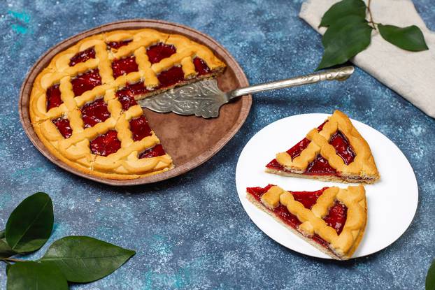 Delicious traditional berry cherry pie Crostata on grey dark background