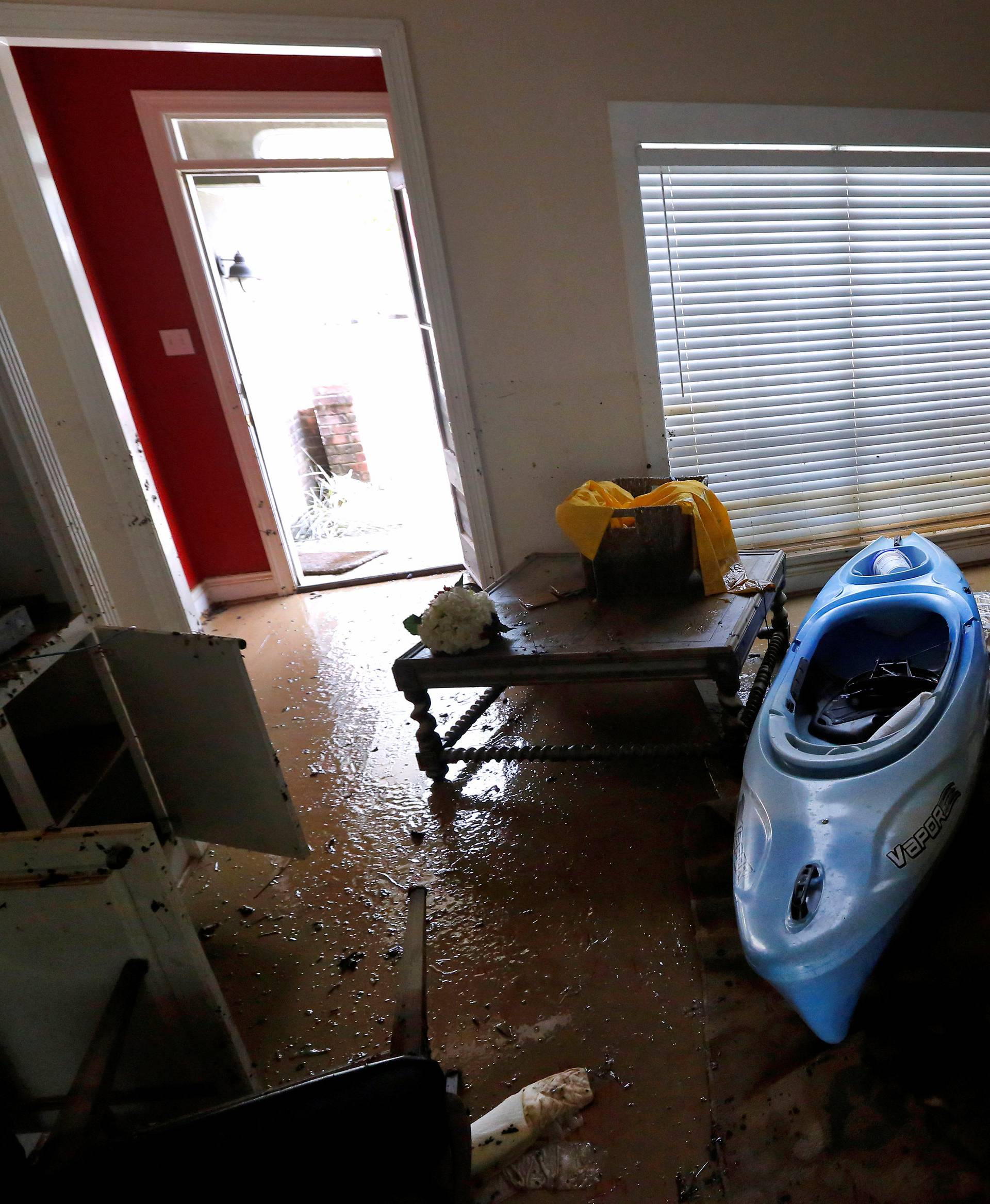 Johnette Folse stands in her flood damaged living room in Denham Springs