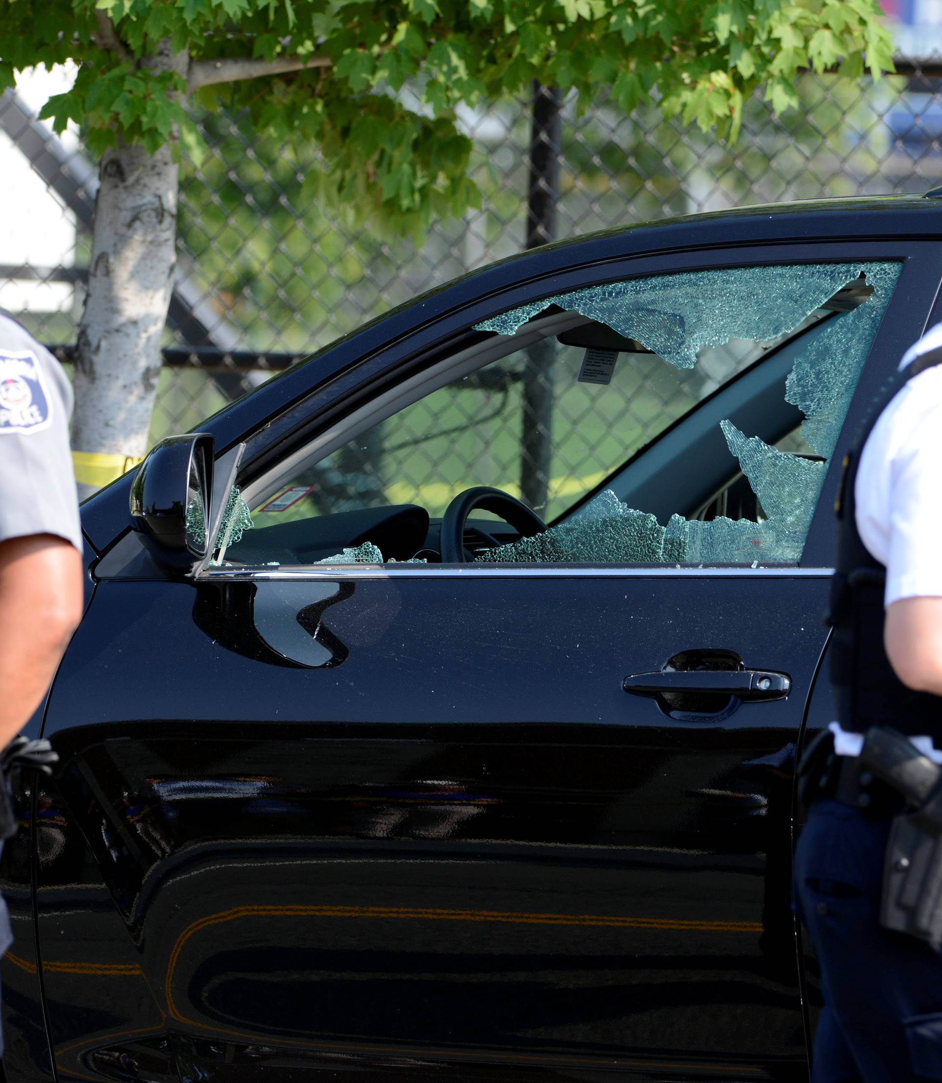 A vehicle window is shattered as police secure the scene where shots were fired during a Congressional baseball practice, wounding House Majority Whip Steve Scalise, in Alexandria
