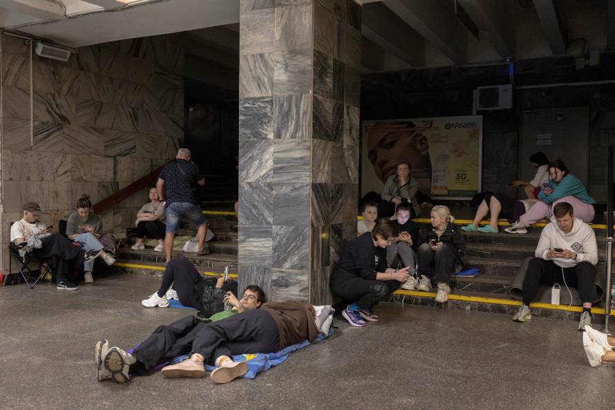 People take shelter in a metro station during Russian drone and missile strikes in Kyiv