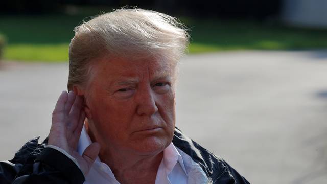 U.S. President Donald Trump listens to a question from a reporter before departing the White House in Washington