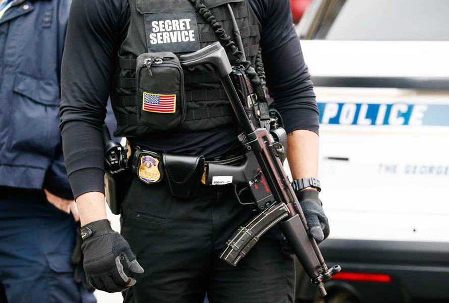A uniformed Secret Service officer is pictured on scene after a passenger vehicle struck a security barrier near the White House in Washington