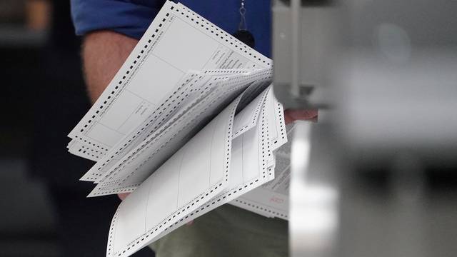 FILE PHOTO: A worker holds ballots before a ballot recount in Lauderhill