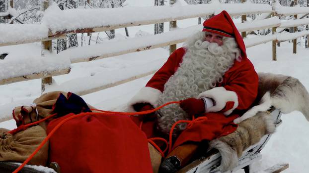 A man dressed as Santa Claus rides his sleigh near the Santa Claus Office located on the Arctic Circle near Rovaniemi