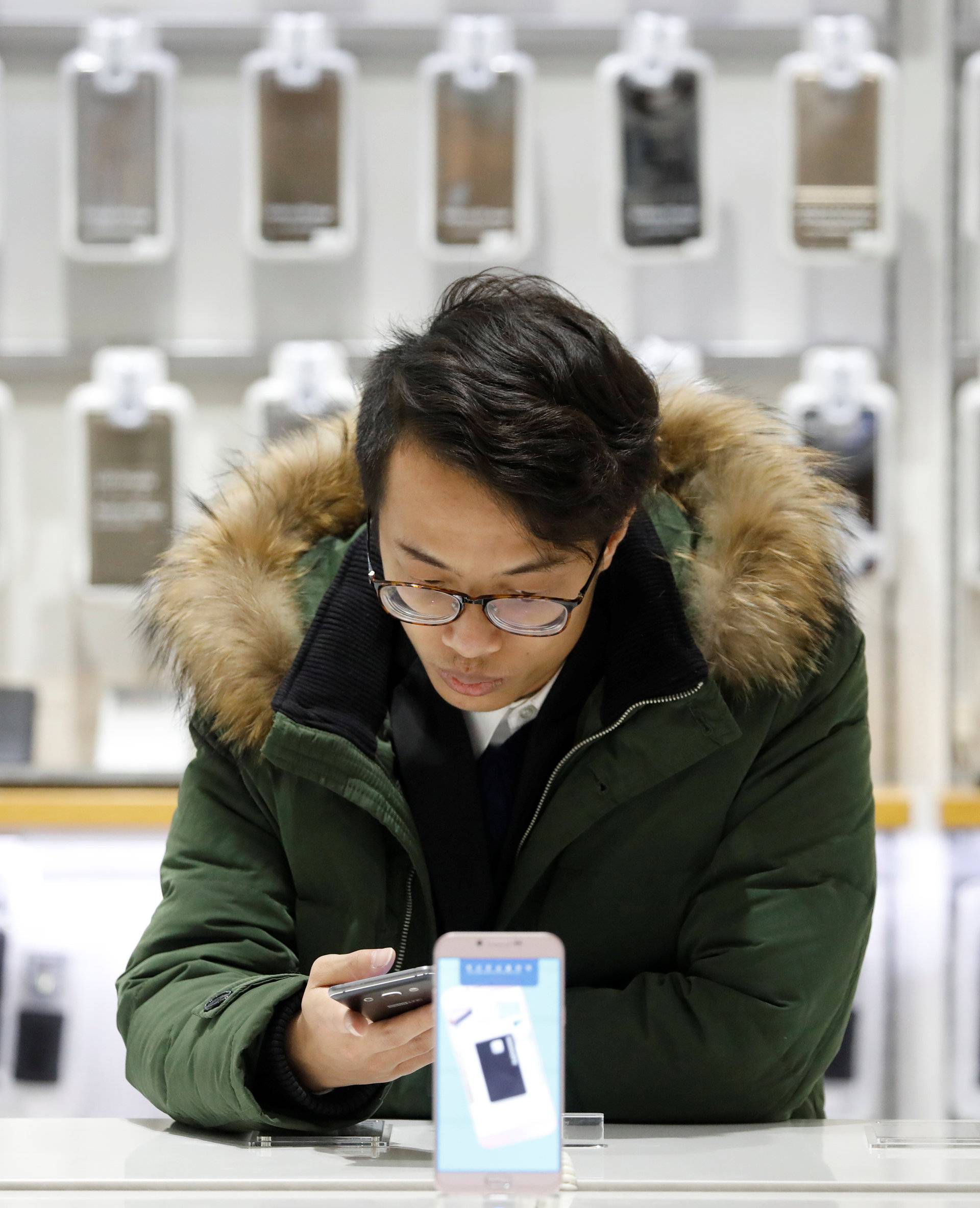 A man tries out a Samsung Electronics' smartphone at its store in Seoul