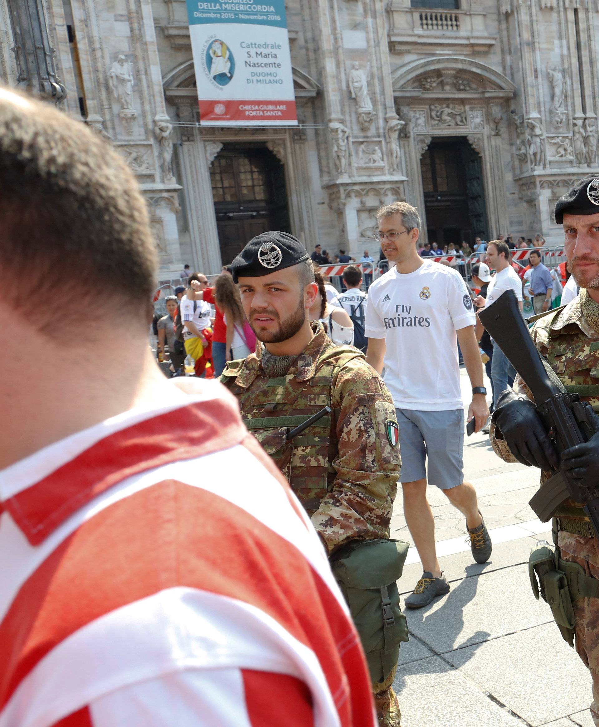 Italian soldiers patrol as Atletico Madrid fans walk in Duomo Square before the Champions League Final between Real Madrid and Atletico Madrid in Milan