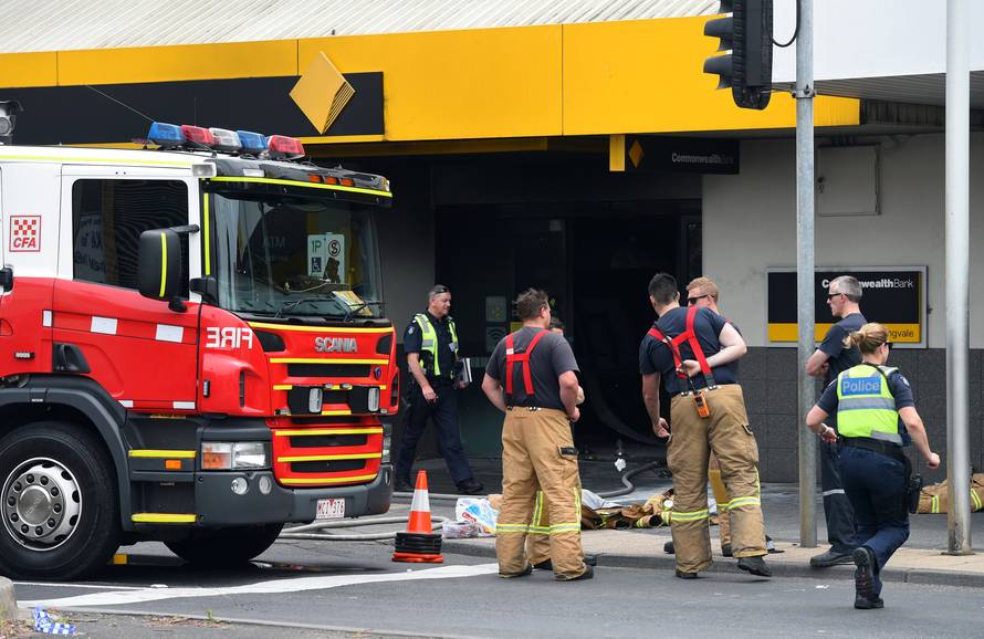 Emergency service workers are seen at a branch of the Commonwealth Bank after a fire injured customers in Melbourne