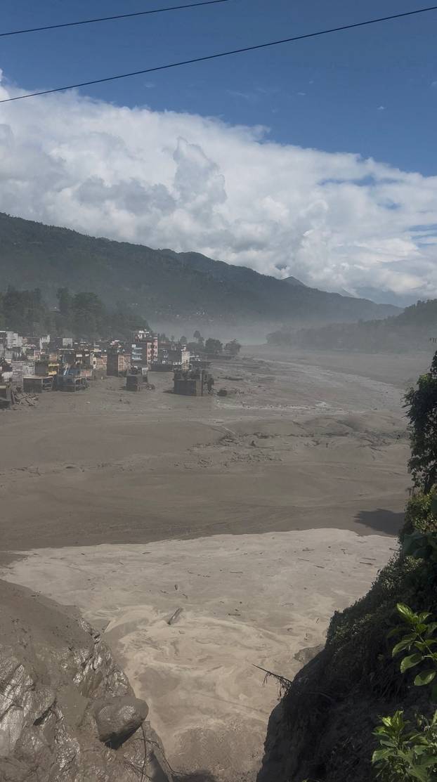 Partially submerged buildings along the riverbank due to a flash flood in Nuwakot district