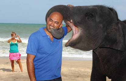 Trogodišnji slon rado se fotka s turistima na plaži 