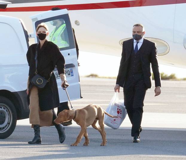 Princess Charlene of Monaco pictured on the tarmac at Nice airport walking the dog on her return after a ten-month stay in South Africa.