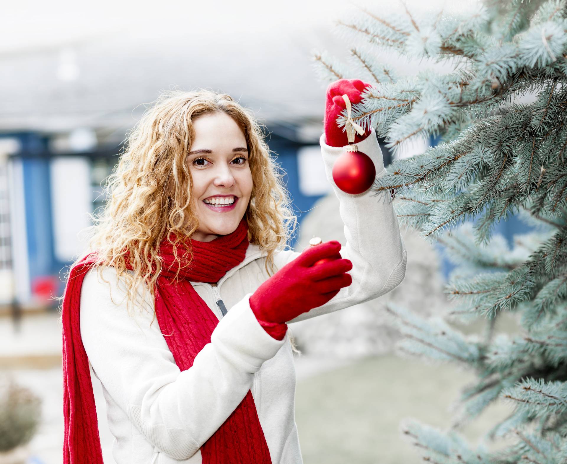 Woman decorating Christmas tree outside