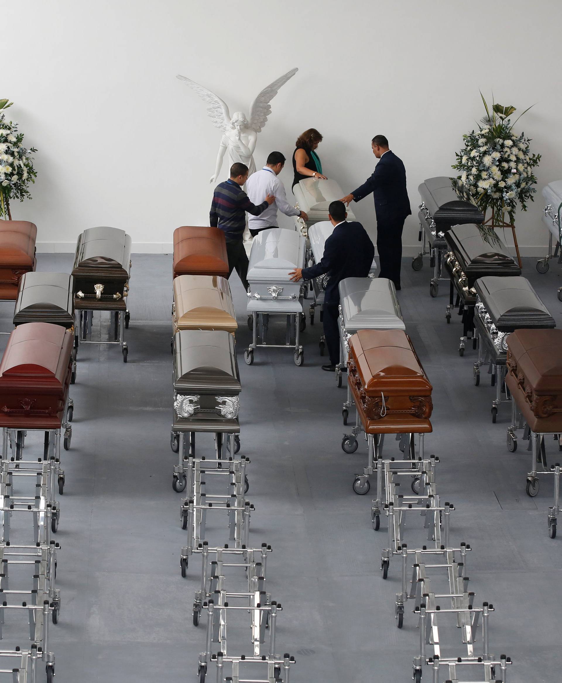 Funeral workers arrange coffins holding the remains of the victims who died in an accident of the plane that crashed into the Colombian jungle with Brazilian soccer team Chapecoense onboard, in Medellin