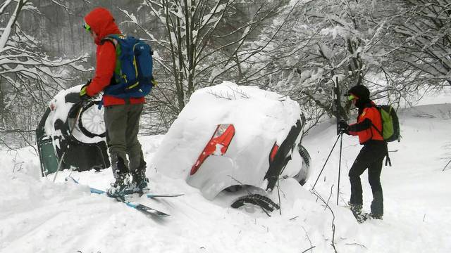 Members of Lazio's Alpine and Speleological Rescue Team are seen next to cars covered in snow in front of the Hotel Rigopiano in Farindola