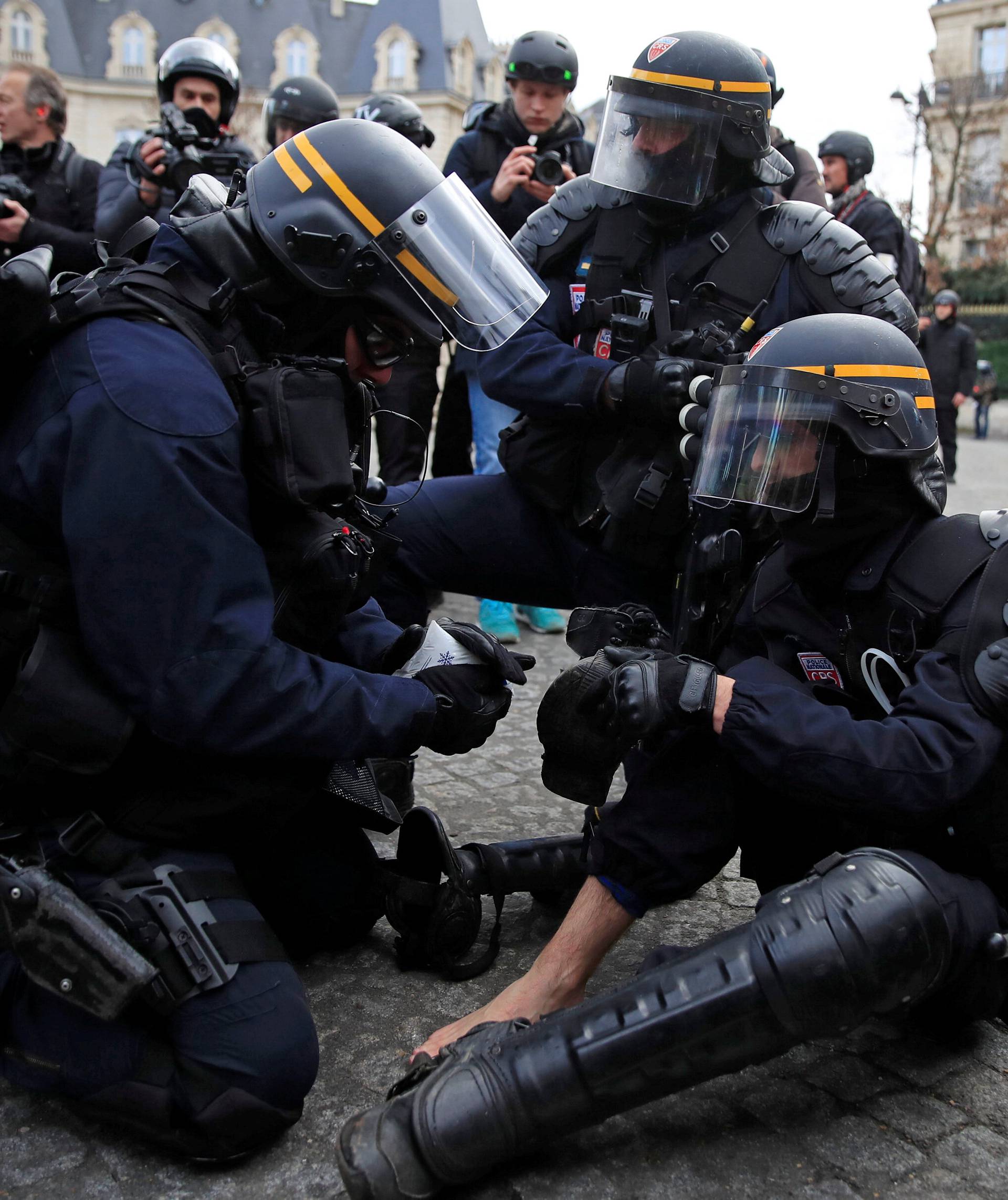 An injured policeman in riot gear is given help during a demonstration by the "yellow vests" movement in Paris