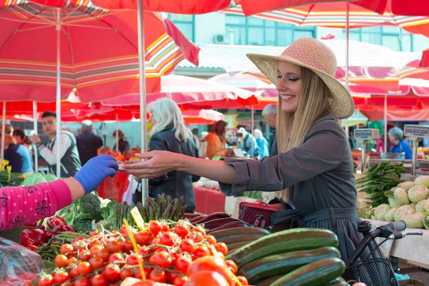 Attractive,Blonde,Girl,With,Straw,Hat,Paying,Vegetables,On,Marketplace.
