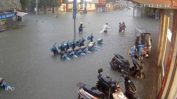 A CCTV footage shows a person who fell into floodwater being assisted by passersby in Fangchenggang