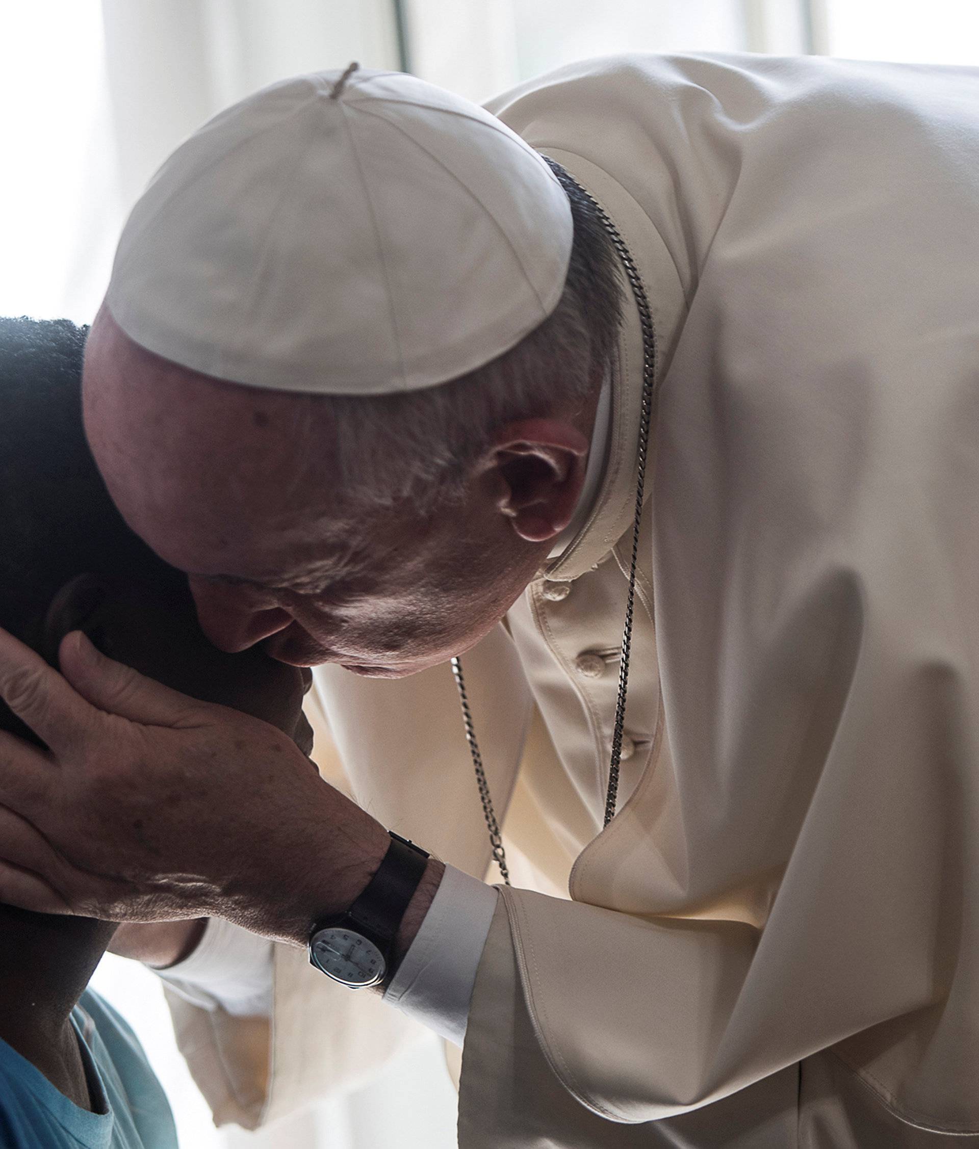 Pope Francis kisses a member of the Pope John XXIII community in Rome