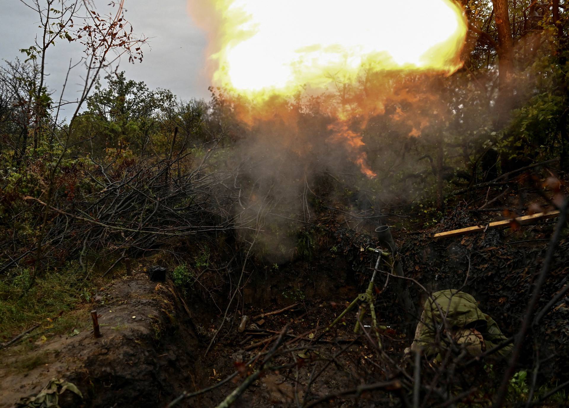 A Ukrainian serviceman fires a mortar toward Russian troops in a front line in Donetsk region