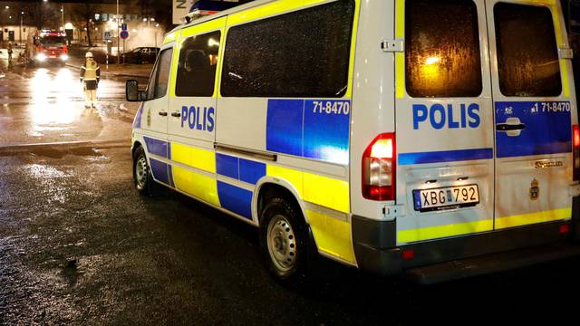 A police car is seen as several cars were set on fire during a riot, according to local media, in Rinkeby suburb, outside Stockholm