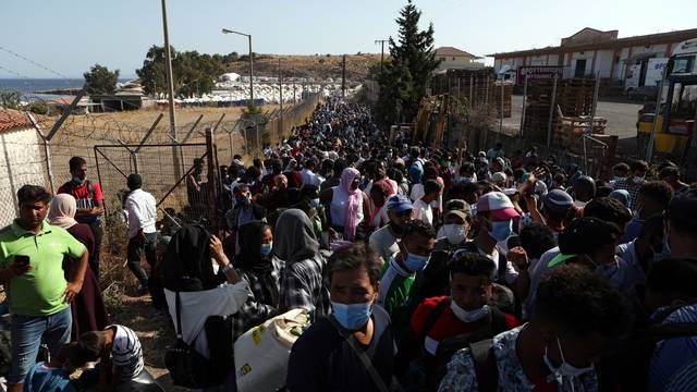 Refugees and migrants from the destroyed Moria camp wait to board busses to the port from where they will be transferred to the mainland, on the island of Lesbos