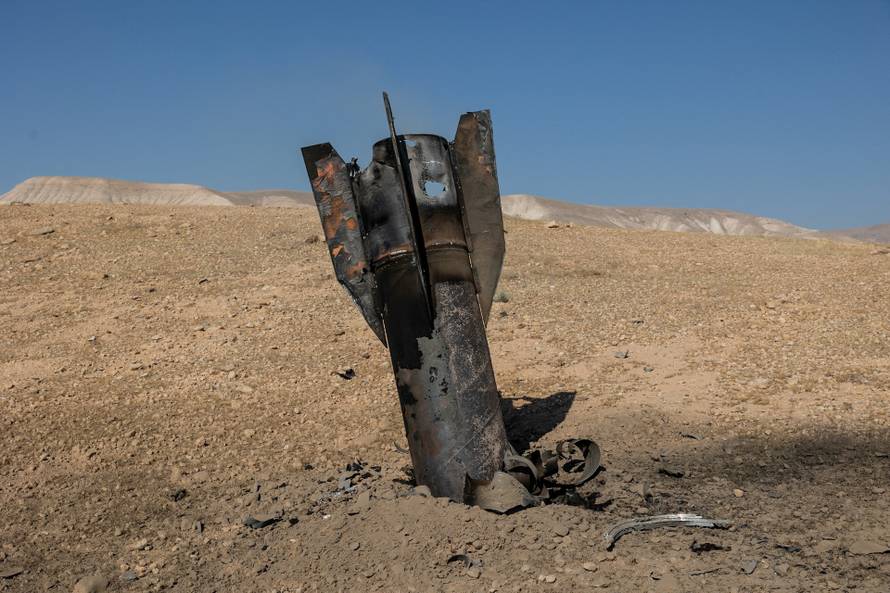 Part of a missile protrudes from the ground, from the ground, following strikes from Iran, in the central Israeli-occupied West Bank
