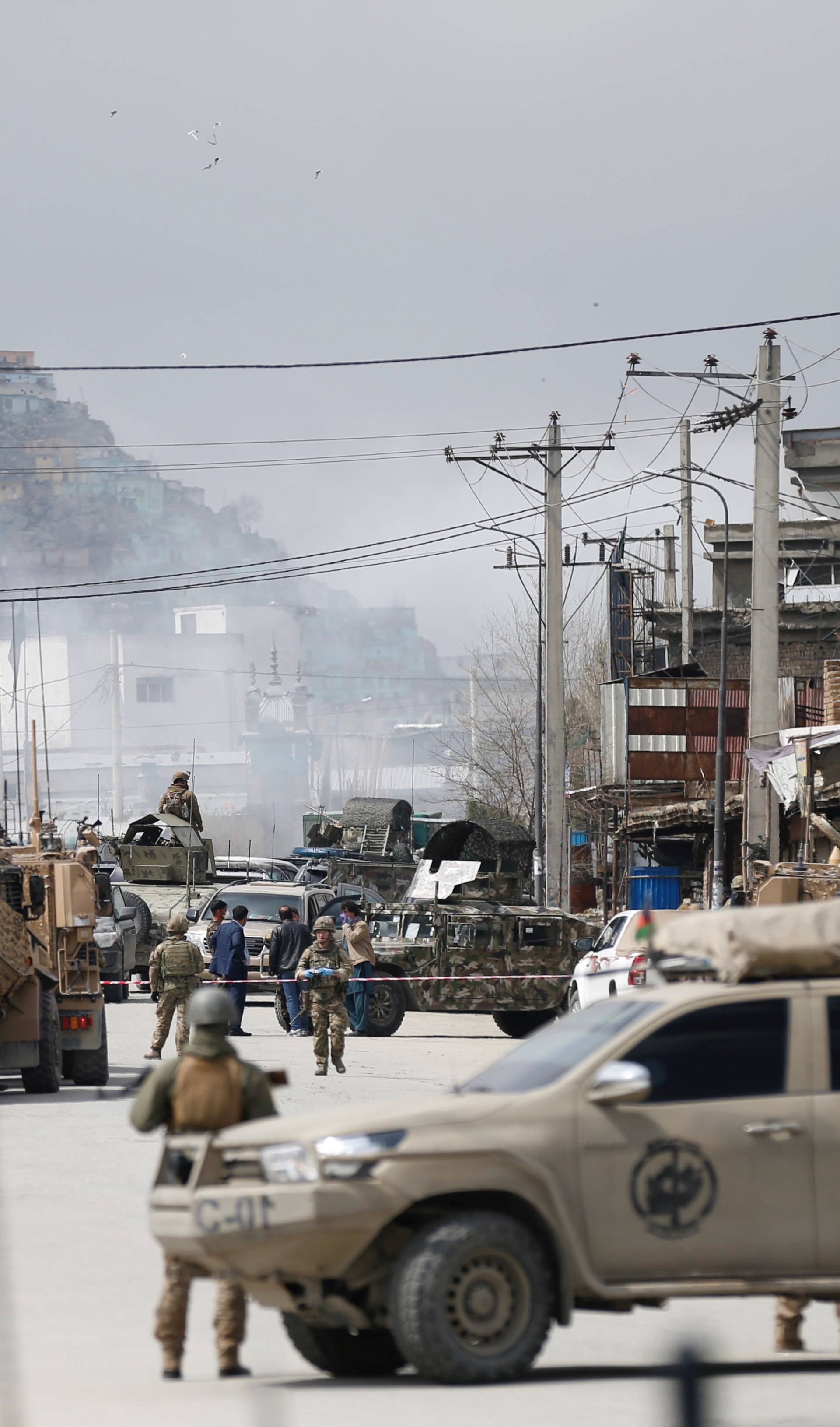 Afghan security forces inspect near the site of an attack in Kabul