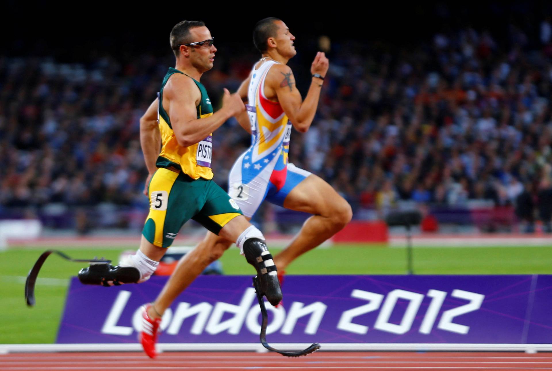FILE PHOTO: South Africa's Oscar Pistorius runs beside Venezuela's Albert Bravo in the men's 400m semi-final during the London 2012 Olympic Games