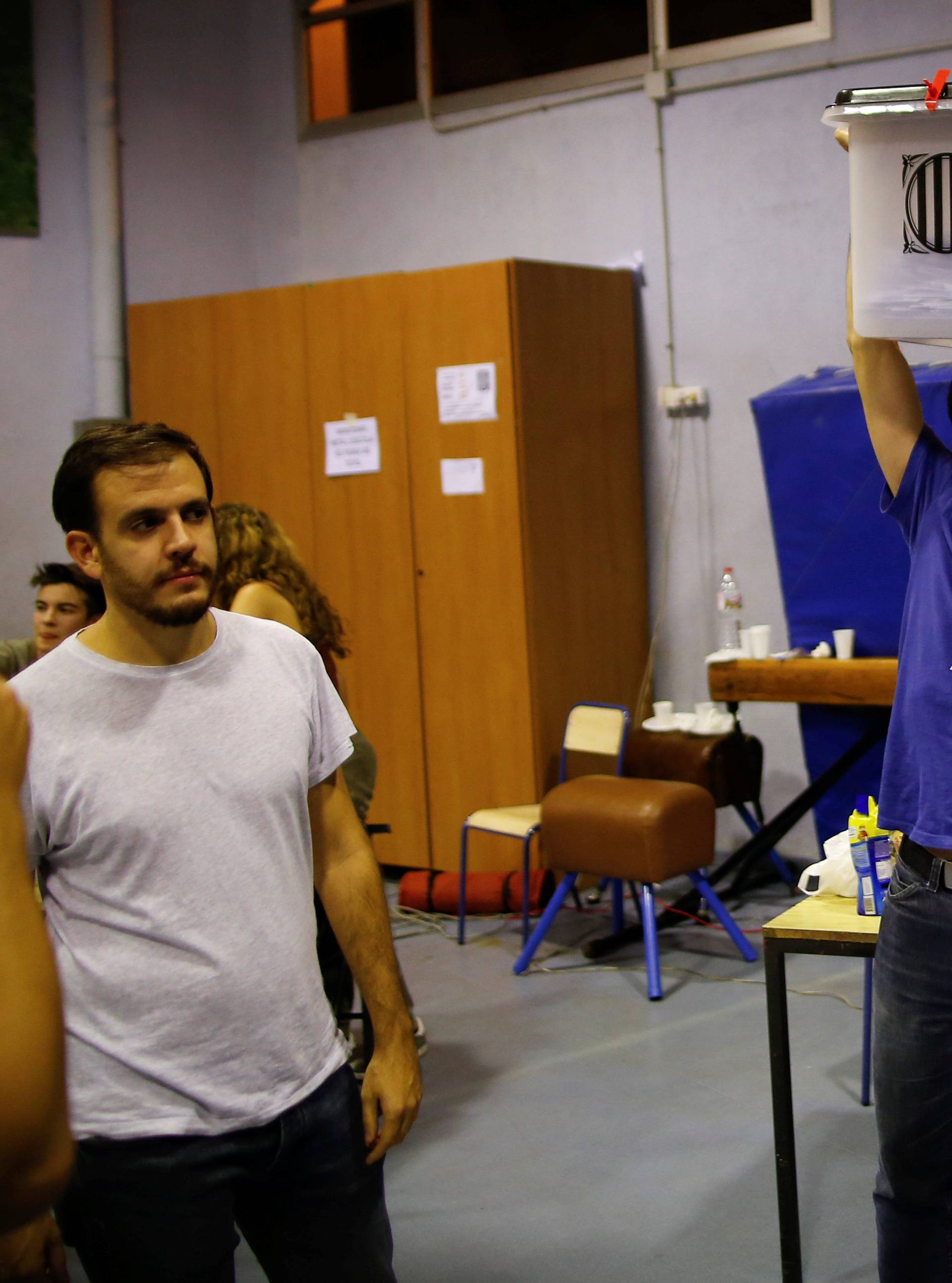 Poll workers celebrate after polls close at a polling station for the banned independence referendum in Barcelona