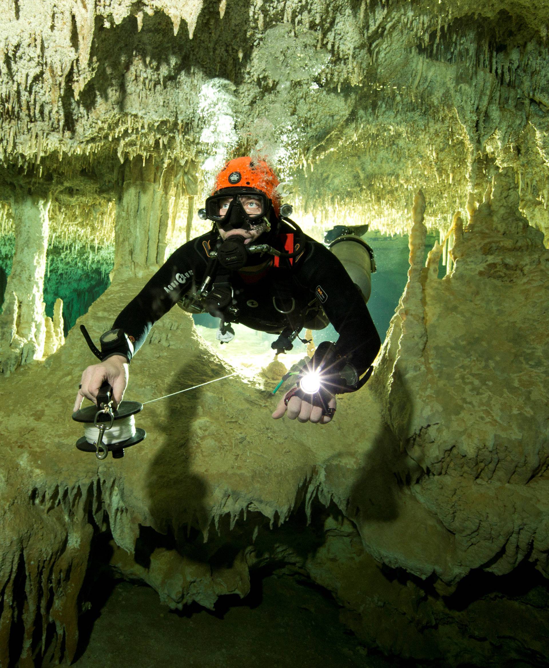 Scuba diver measures the length of Sac Aktun underwater cave system as part of the Gran Acuifero Maya Project near Tulum