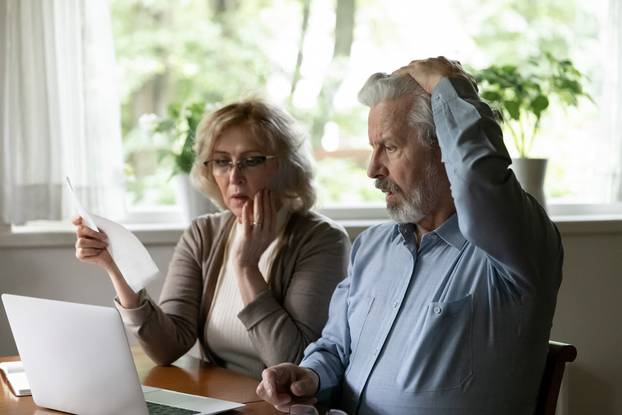 Unhappy,Shocked,Mature,Man,And,Woman,Reading,Documents,,Loan,Agreement,