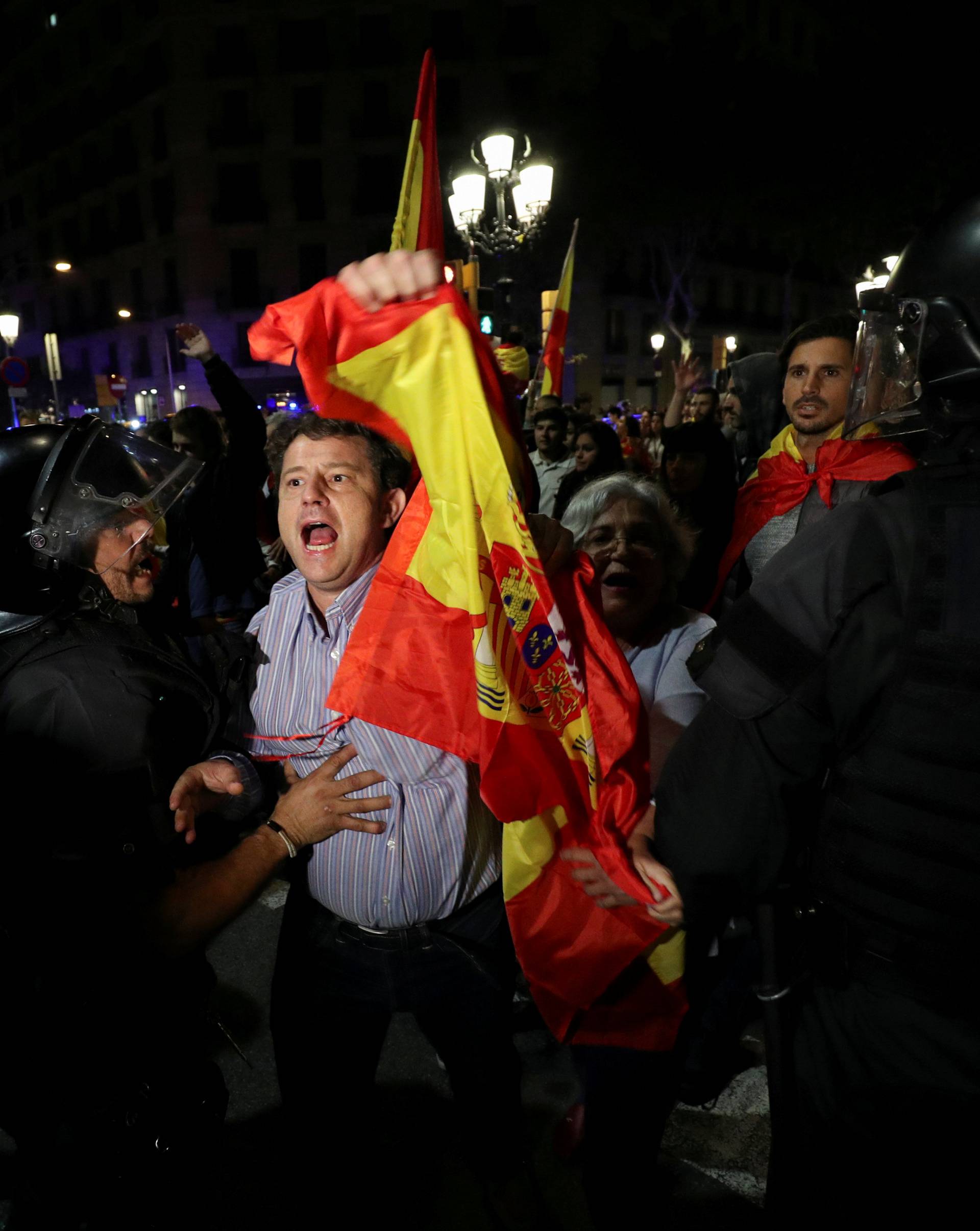 A pro unity demonstrator is stopped by Catalan Regional Police officer during a protest after the Catalan regional parliament declared independence from Spain in Barcelona