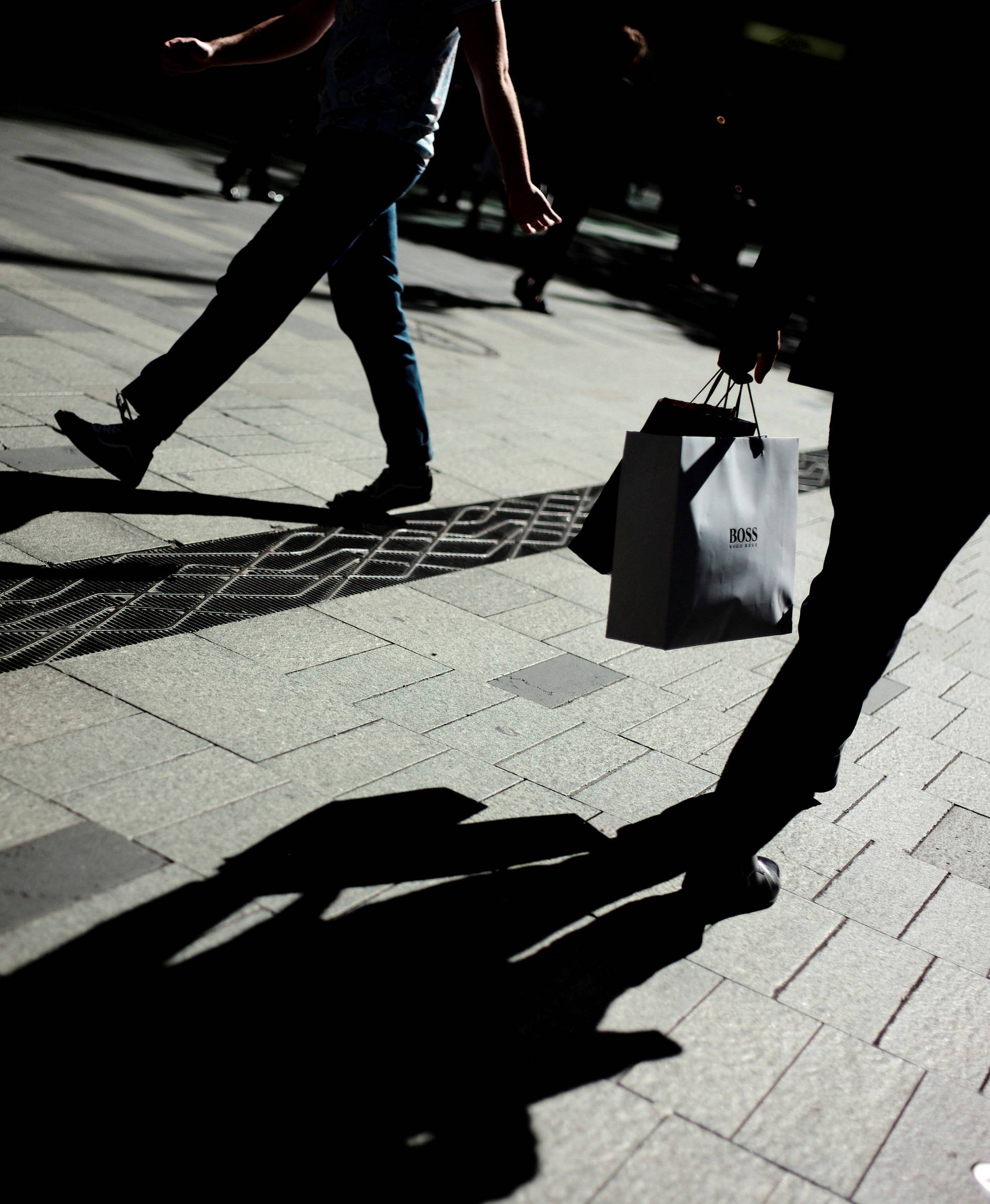 A shopper carries shopping bags from a fashion store in Sydney's central retail district