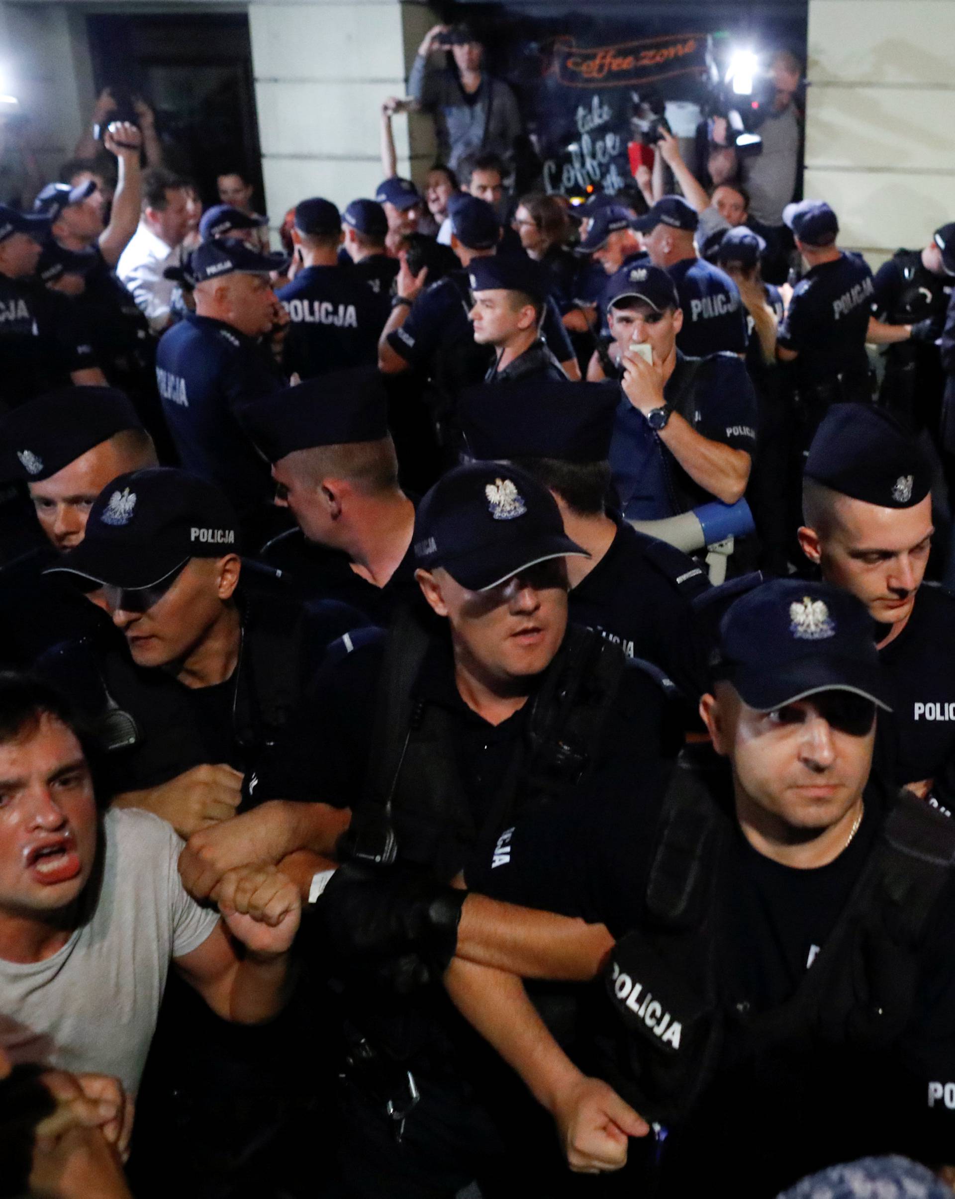 People chant slogans amid police officers during the "Chain of lights" protest against judicial overhaul in front of the Presidential Palace in Warsaw